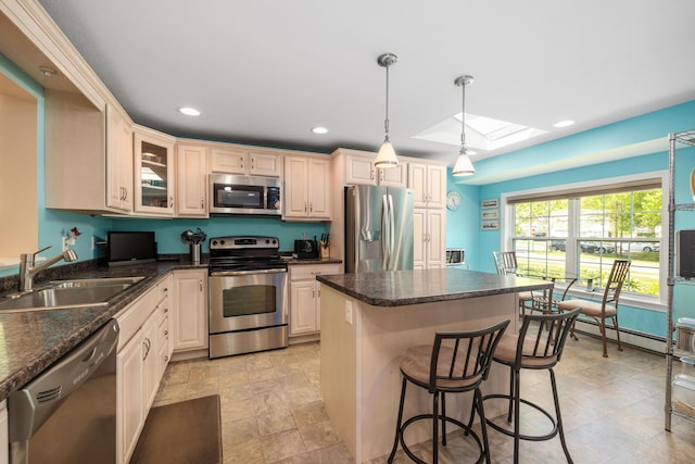 76 Heritage Dr Unit 5, Wells, ME 04090 - kitchen featuring appliances with stainless steel finishes, a sink, a center island, a skylight, and a kitchen bar
