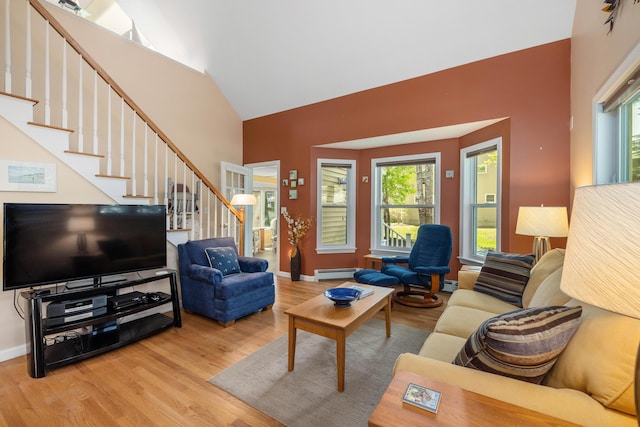 76 Heritage Dr Unit 5, Wells, ME 04090 - living area featuring wood finished floors, stairway, baseboard heating, baseboards, and high vaulted ceiling