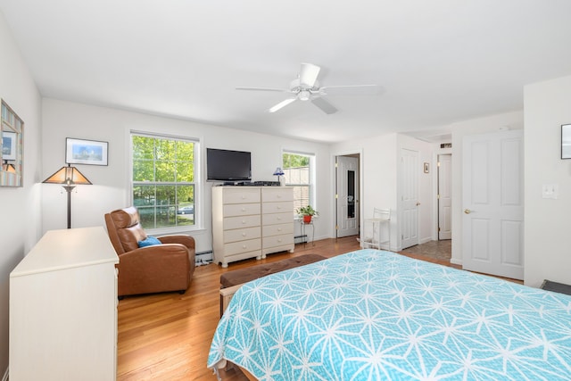 76 Heritage Dr Unit 5, Wells, ME 04090 - bedroom with wood finished floors, a ceiling fan, a baseboard radiator, and baseboard heating