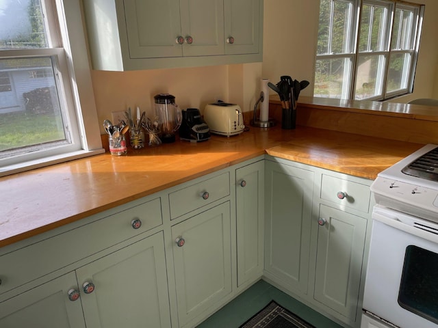 122 Main St, Cranberry Isles, ME 04646 - kitchen featuring green cabinetry, white range, a wealth of natural light, and butcher block counters