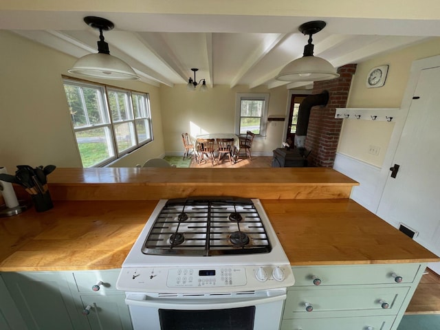 122 Main St, Cranberry Isles, ME 04646 - kitchen with pendant lighting, beamed ceiling, a wood stove, and white range oven