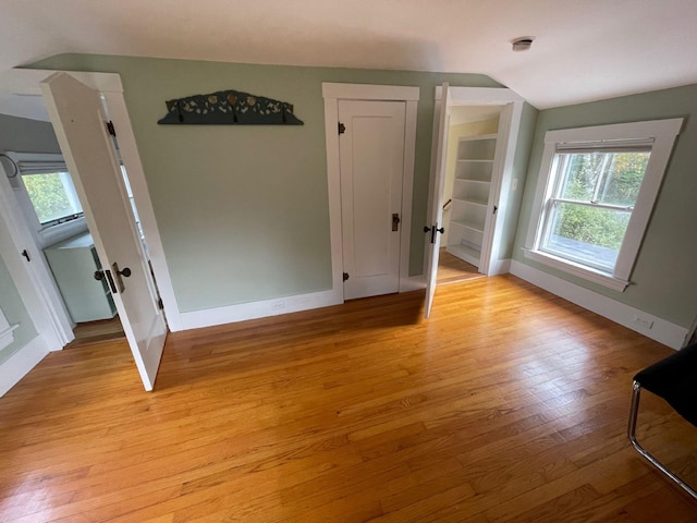 122 Main St, Cranberry Isles, ME 04646 - spare room with light hardwood / wood-style floors, vaulted ceiling, and built in shelves