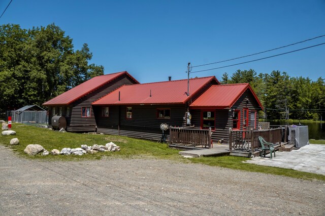 log cabin with a deck and a front lawn