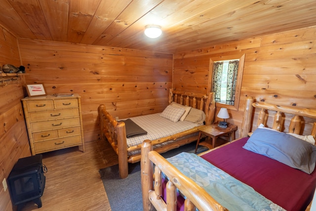 bedroom featuring wood ceiling and a wood stove