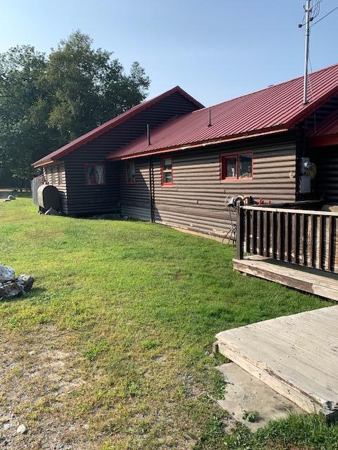 view of property exterior with a yard and a wooden deck