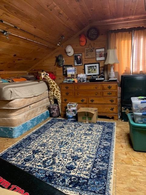 bedroom featuring wooden walls, wooden ceiling, and lofted ceiling