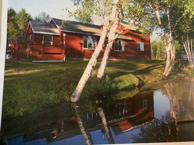 rear view of house featuring a yard and a wooden deck