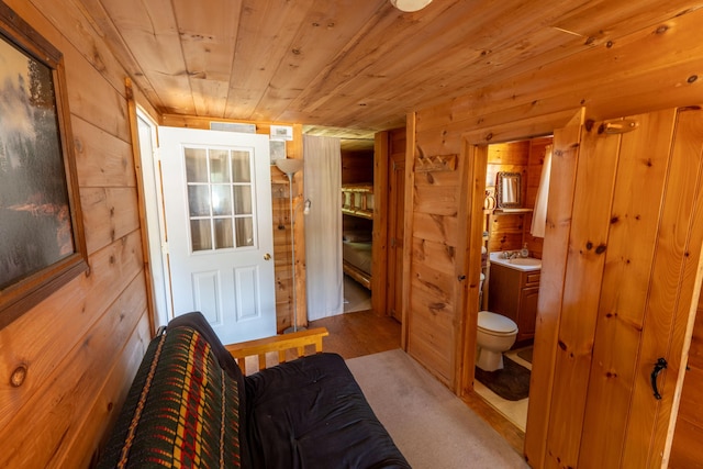 bathroom with toilet, wooden ceiling, wood walls, and vanity