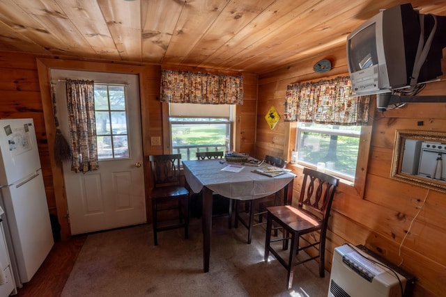 dining room with wood walls, heating unit, and wood ceiling