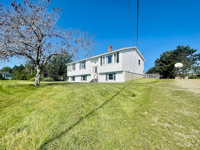 rear view of house featuring a lawn