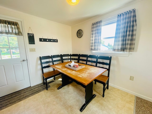 dining space featuring light tile floors and crown molding