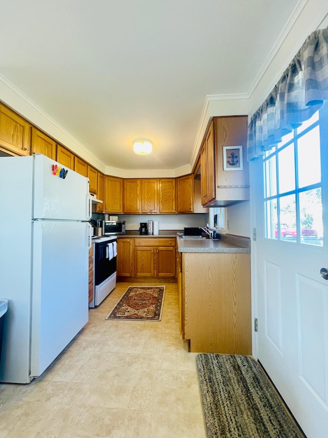 kitchen featuring light tile flooring, ornamental molding, range, and white fridge