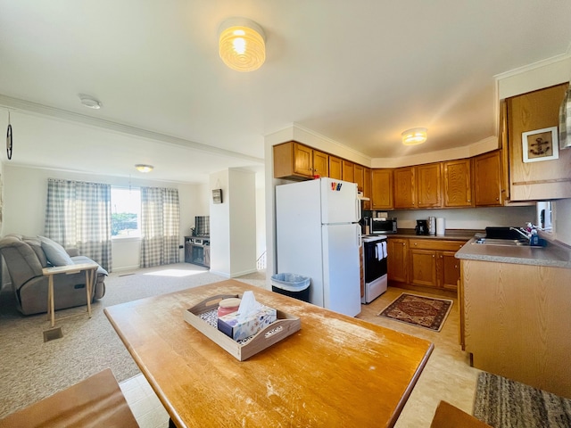 kitchen with range, white refrigerator, light carpet, and sink