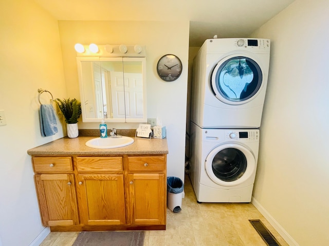 laundry room featuring stacked washer / dryer and sink