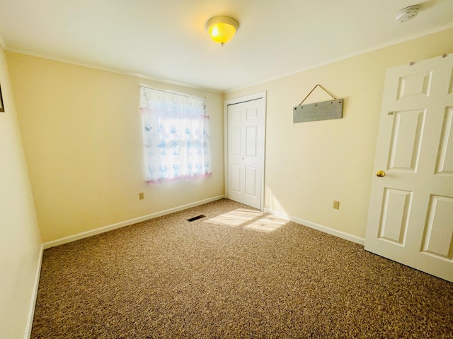 unfurnished bedroom with a closet and light colored carpet