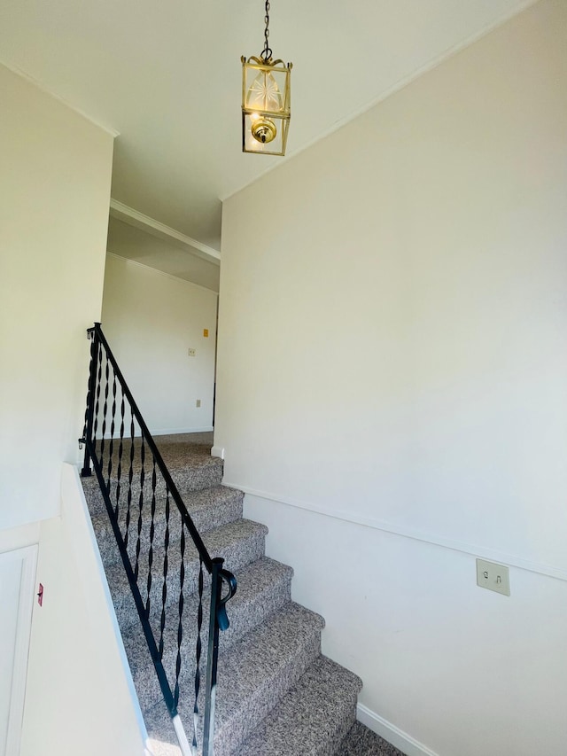 staircase featuring a notable chandelier