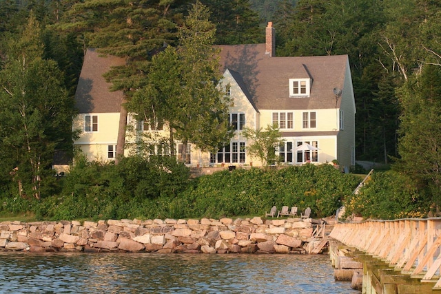 rear view of house featuring a water view