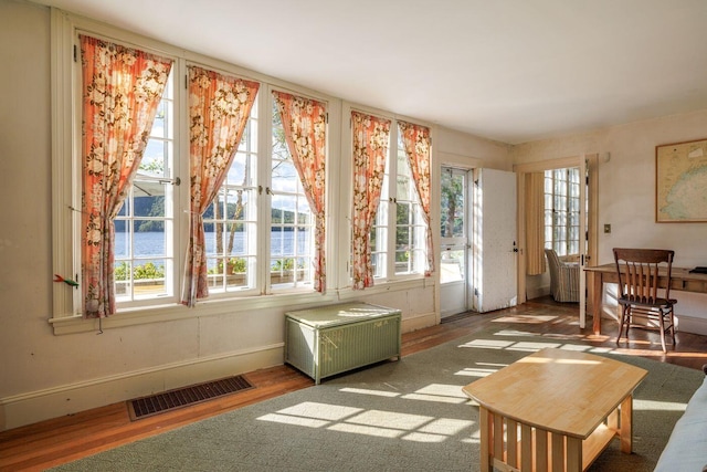 sunroom featuring a water view and radiator