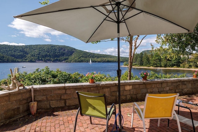 view of patio / terrace with a water and mountain view