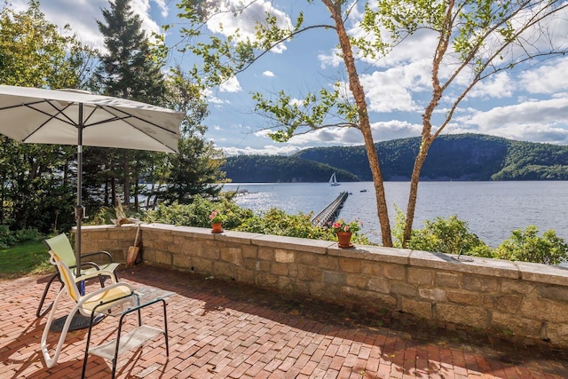 view of patio with a water and mountain view