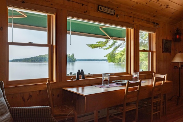228 Starbird Ln, Rome, ME 04963 - dining space with plenty of natural light, a water view, and wood walls