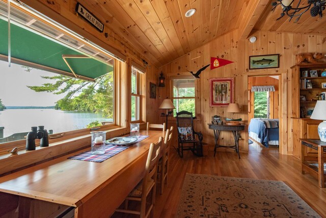 228 Starbird Ln, Rome, ME 04963 - dining space with vaulted ceiling, wood finished floors, wooden walls, wooden ceiling, and a water view