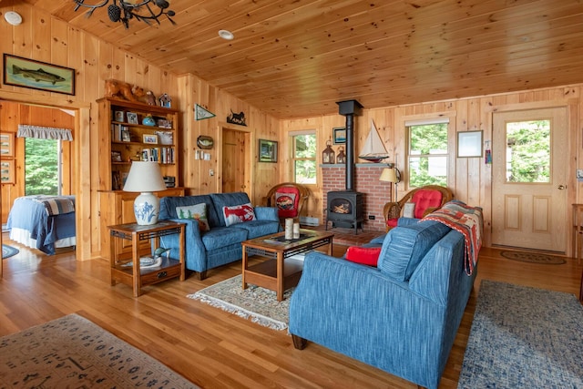 228 Starbird Ln, Rome, ME 04963 - living room featuring a wood stove, wood walls, vaulted ceiling, wood finished floors, and wooden ceiling
