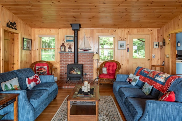 228 Starbird Ln, Rome, ME 04963 - living room featuring a wood stove, wood finished floors, wood ceiling, and wood walls