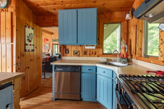 228 Starbird Ln, Rome, ME 04963 - kitchen featuring stainless steel dishwasher, a sink, wooden walls, plenty of natural light, and light countertops