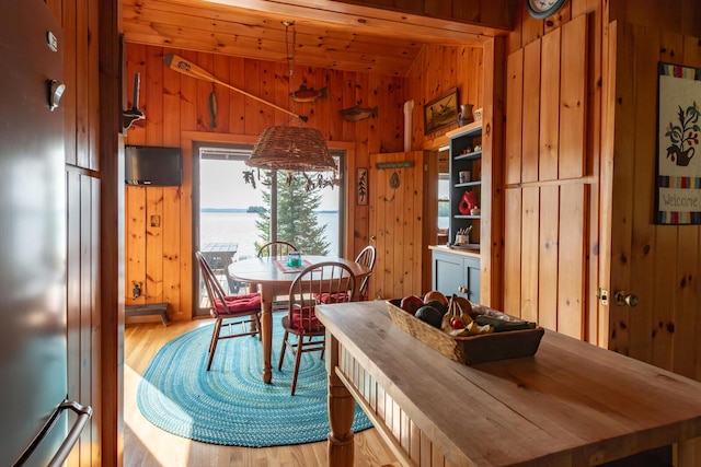 228 Starbird Ln, Rome, ME 04963 - dining room featuring wooden walls, light wood-style flooring, vaulted ceiling, and wood ceiling