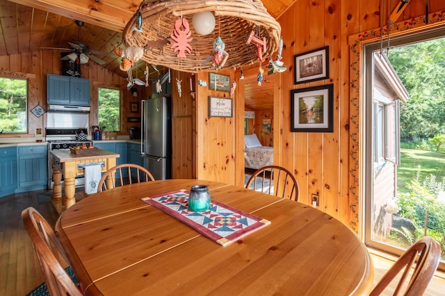 228 Starbird Ln, Rome, ME 04963 - dining room featuring wood finished floors, lofted ceiling, wood walls, and a ceiling fan