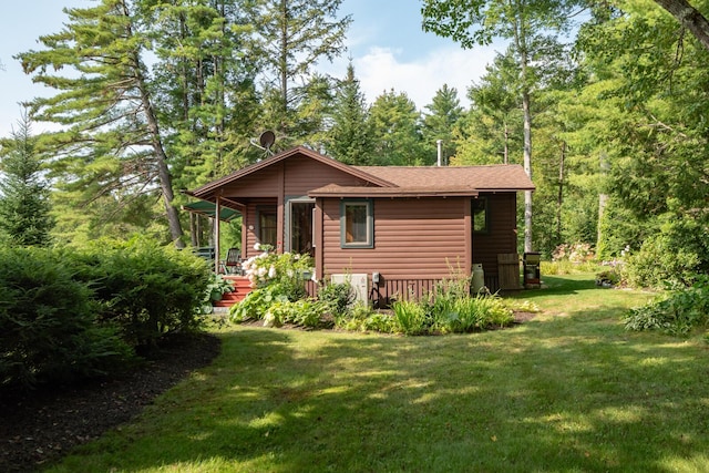 228 Starbird Ln, Rome, ME 04963 - view of side of home featuring a yard, covered porch, and a wooded view