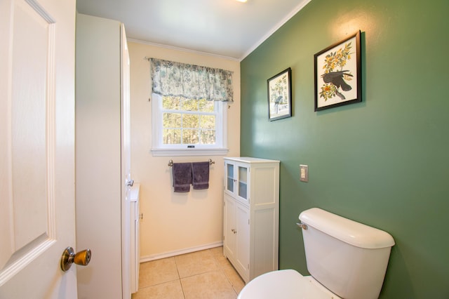 bathroom featuring tile patterned flooring, toilet, and crown molding