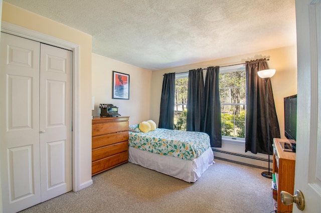 bedroom featuring a baseboard radiator, light carpet, and a textured ceiling