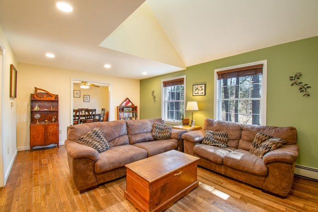 living room featuring lofted ceiling, baseboard heating, recessed lighting, baseboards, and wood-type flooring