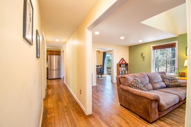 living room with baseboards, light wood-style floors, and recessed lighting