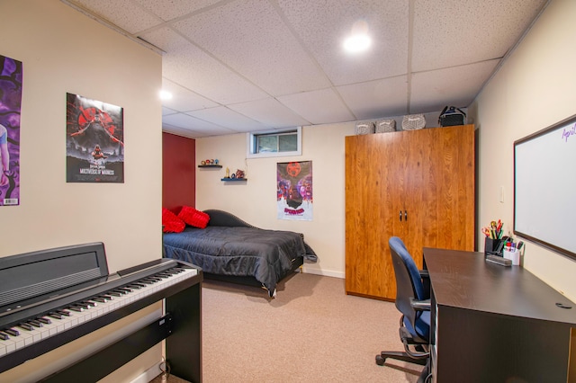 carpeted bedroom featuring a drop ceiling