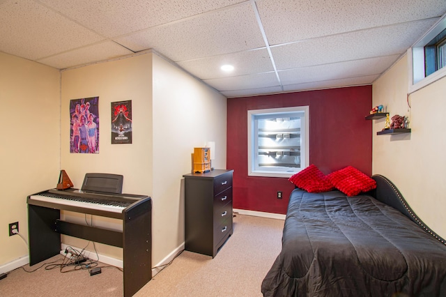carpeted bedroom featuring a paneled ceiling and baseboards