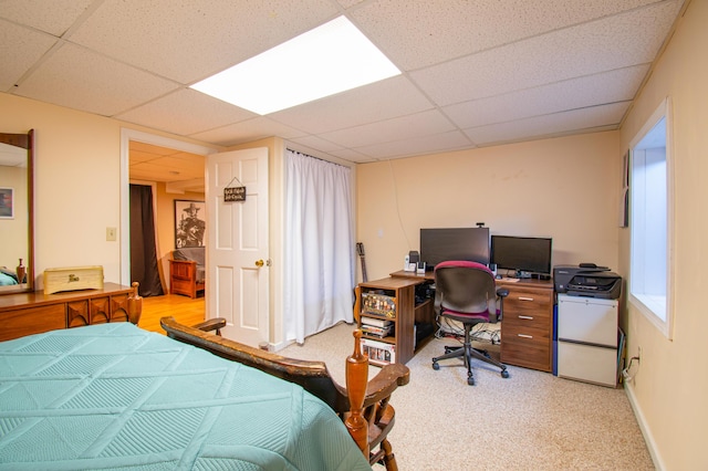 bedroom with carpet, a drop ceiling, and baseboards