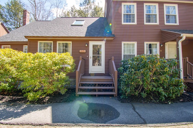 view of front of home featuring a shingled roof and a chimney