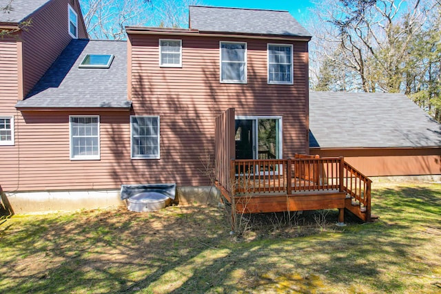 back of property featuring a yard, roof with shingles, and a deck
