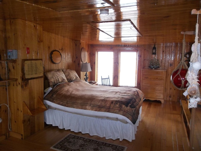 bedroom with dark hardwood / wood-style floors, wood walls, and vaulted ceiling