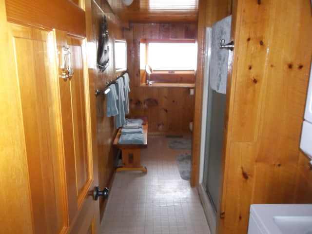 bathroom with tile floors and wooden walls