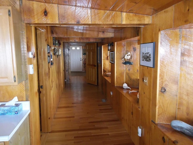 hallway featuring wood walls and dark hardwood / wood-style flooring