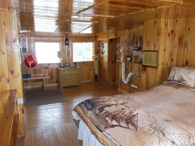 bedroom featuring wooden walls and light hardwood / wood-style floors