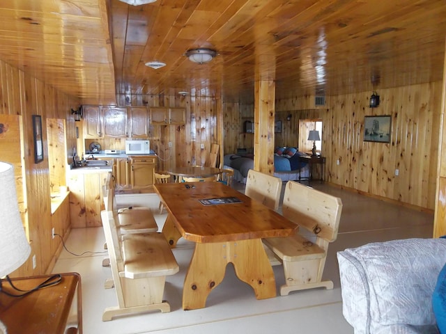 dining area with wooden ceiling and wood walls