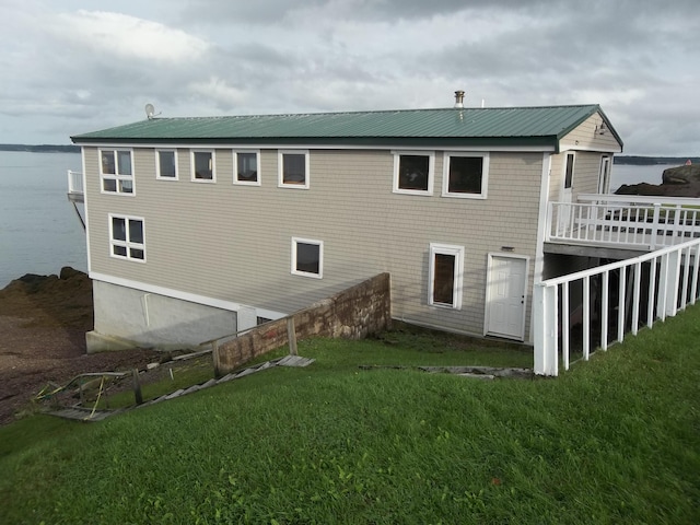 rear view of house featuring a water view and a yard