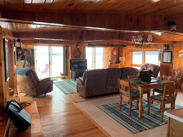 dining space featuring wood ceiling, lofted ceiling, light hardwood / wood-style floors, and wooden walls