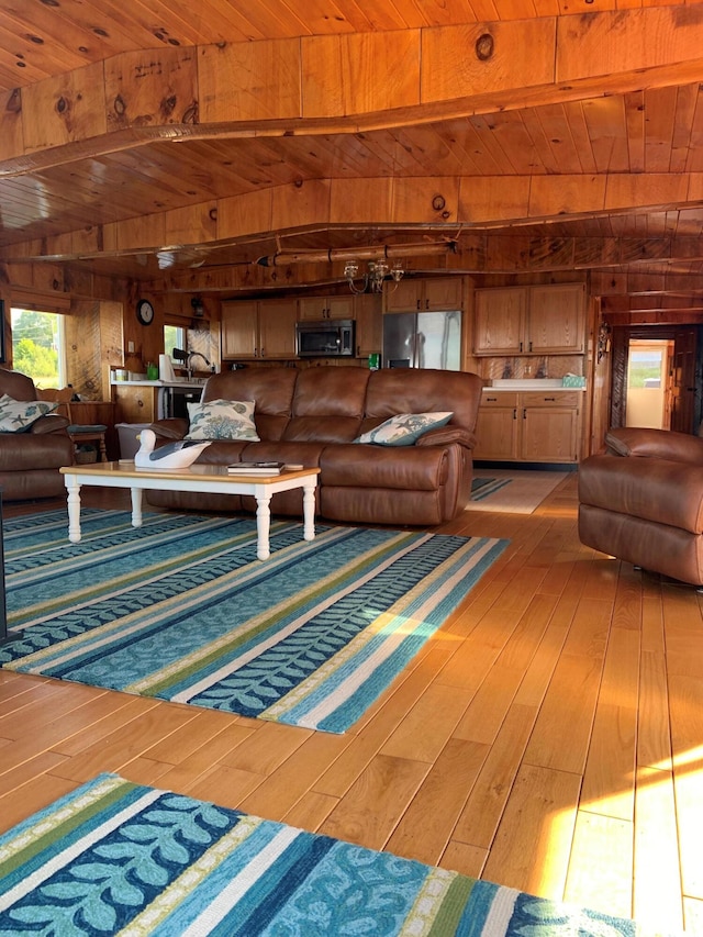 living room with hardwood / wood-style flooring, wood ceiling, wooden walls, and beamed ceiling