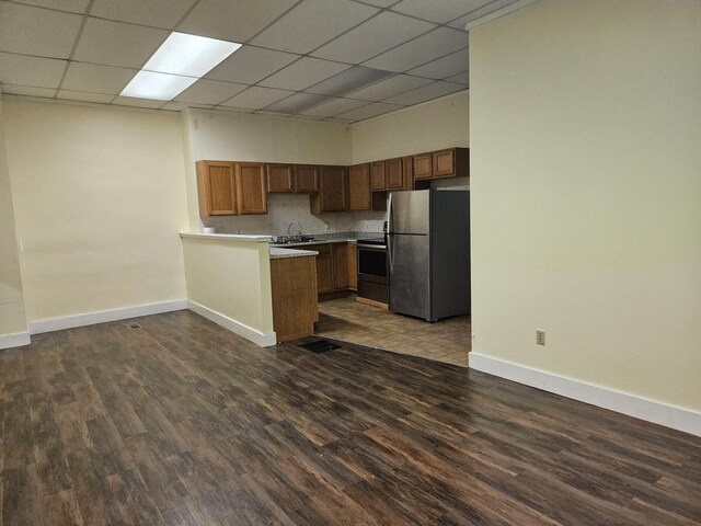 55 Cony St, Augusta, ME 04330 - kitchen with appliances with stainless steel finishes, a peninsula, baseboards, dark wood-style floors, and a paneled ceiling